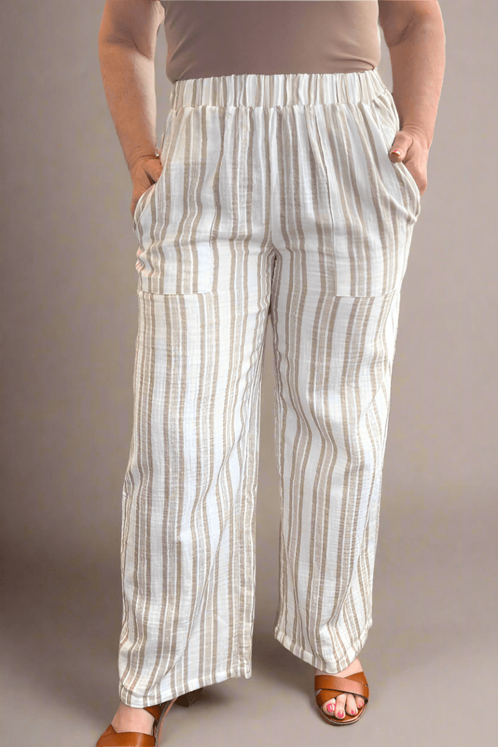 Woman wearing Eighty-five beige cotton gauze wide leg pants featuring a high-rise elastic waistband and front patch pockets.