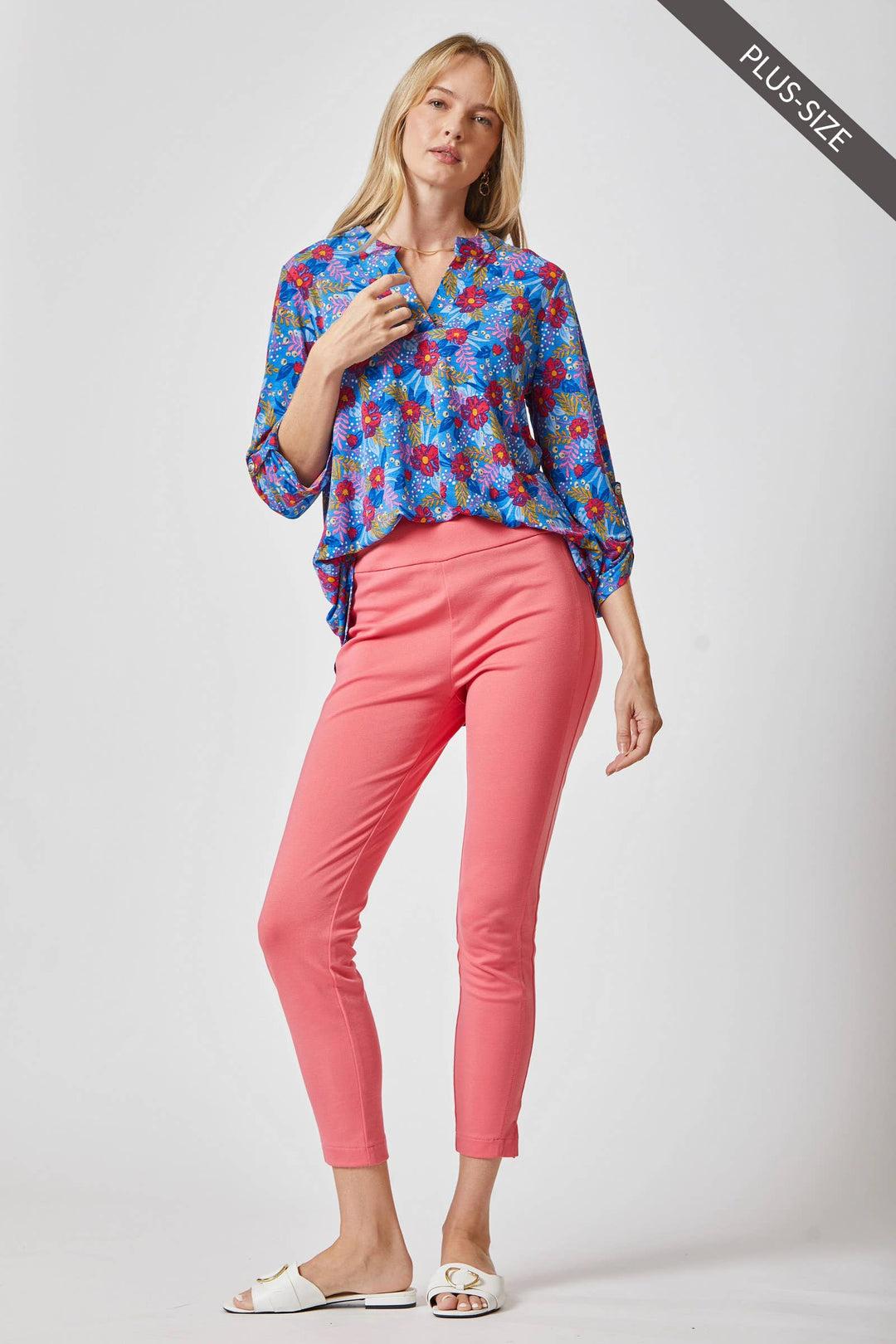 Full-length outfit view of the Curvy Lizzy blouse paired with coral trousers and white buckled sandals.