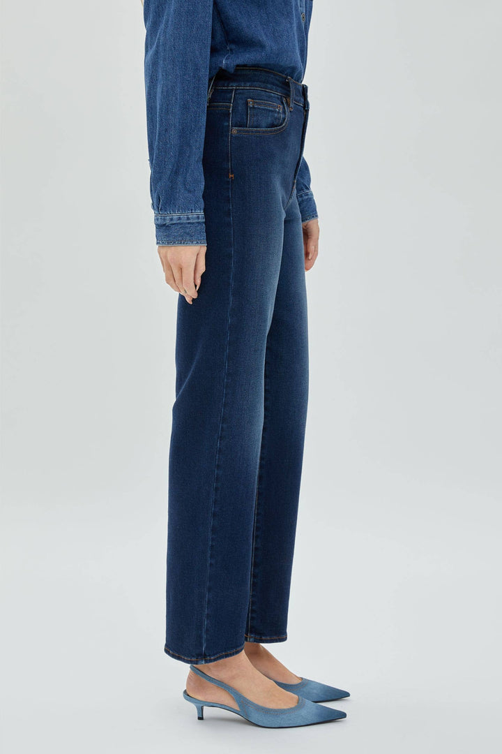 Woman wearing a dark wash denim viewed side on.