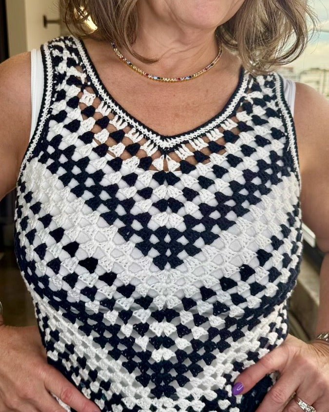Close-up of scalloped V-neckline trim and black and white granny square crochet pattern on Dear John Madeira Cotton Crochet Top
