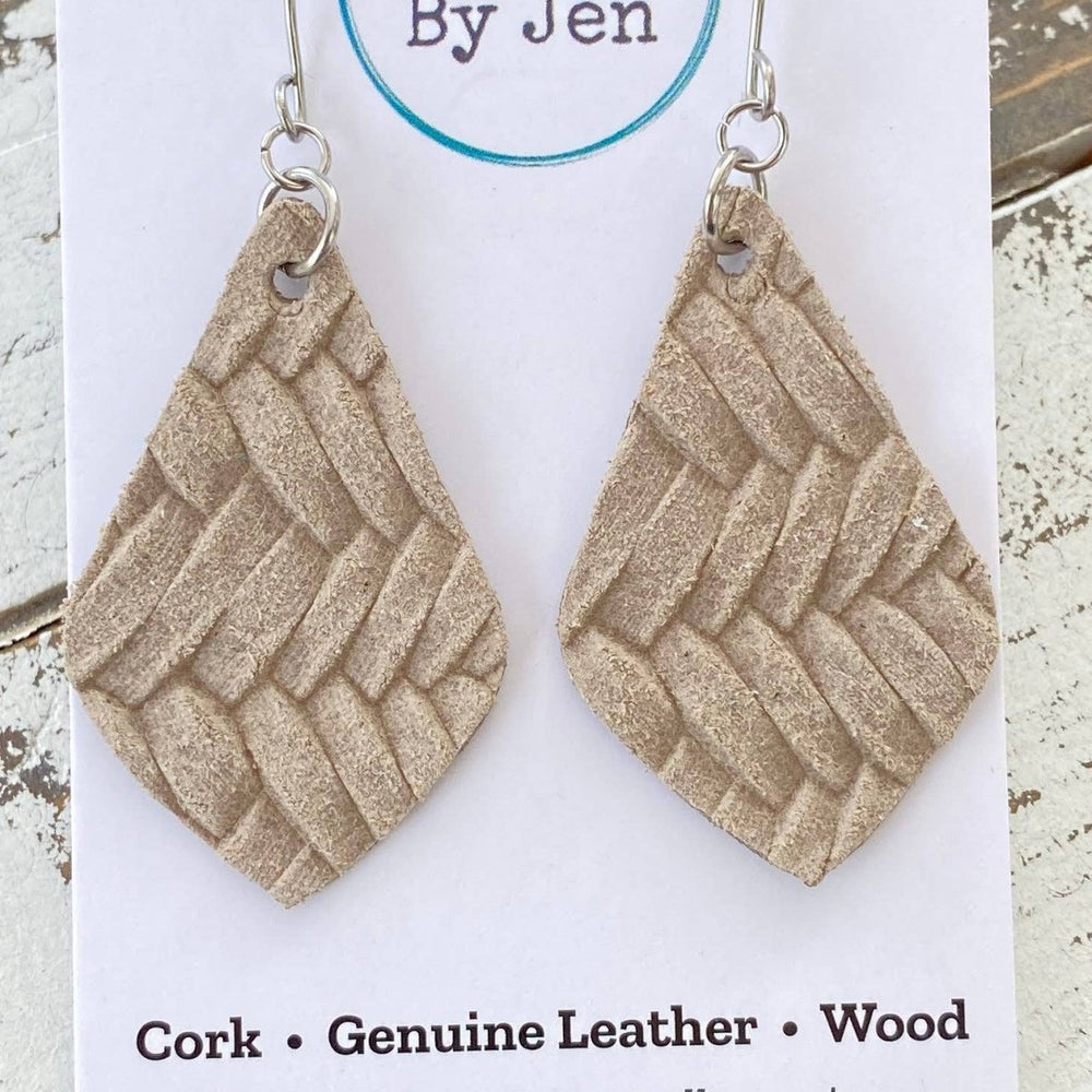 Pair of beige woven earrings on a 'Jewelry By Jen' card with wooden background