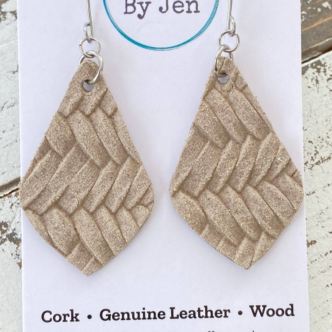 Pair of beige woven earrings on a &
