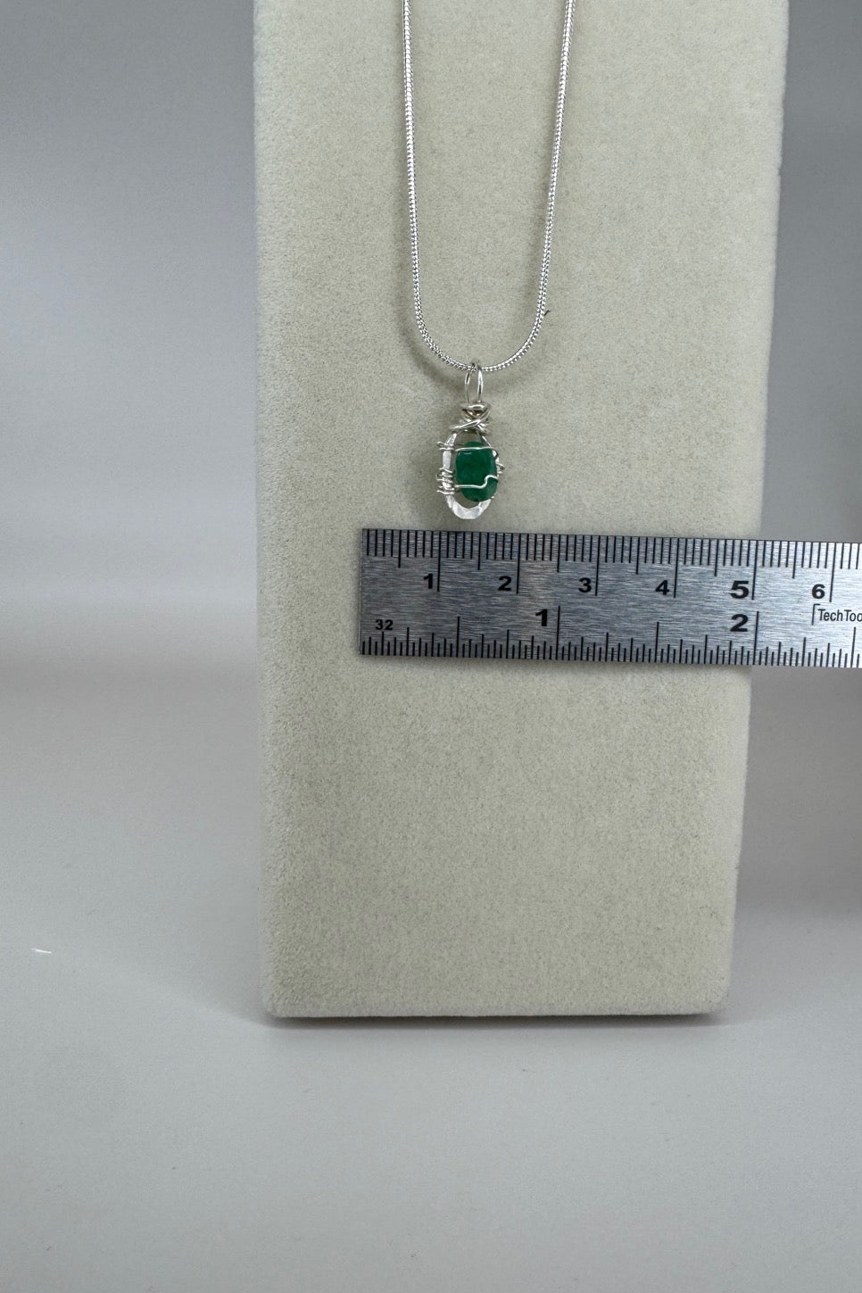Raw Emerald Wire-Wrapped Pendant Necklace in Green &amp; Silver — close-up of pendant and wire wrapping beside ruler