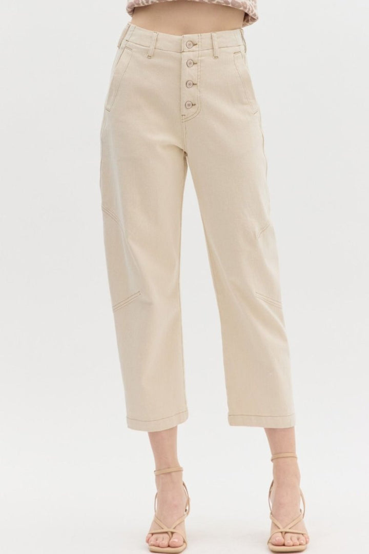 Woman wearing Entro ecru high-waist straight leg pants featuring front seam detailing and button closure.