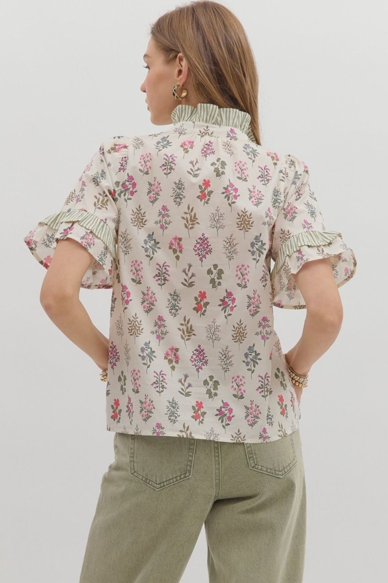 Back view of Entro cream floral top showing the relaxed fit and striped ruffle collar detail.