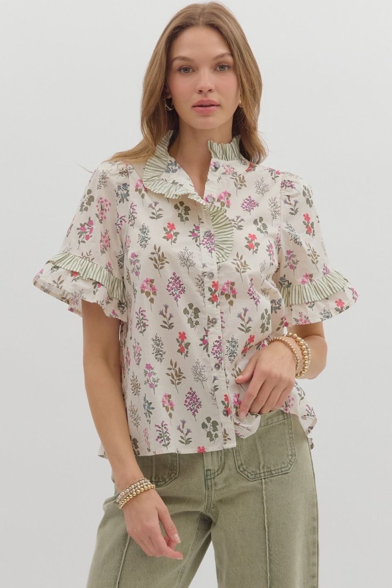 Woman wearing Entro floral button-front top with striped ruffle neckline and puff sleeves with olive pants.