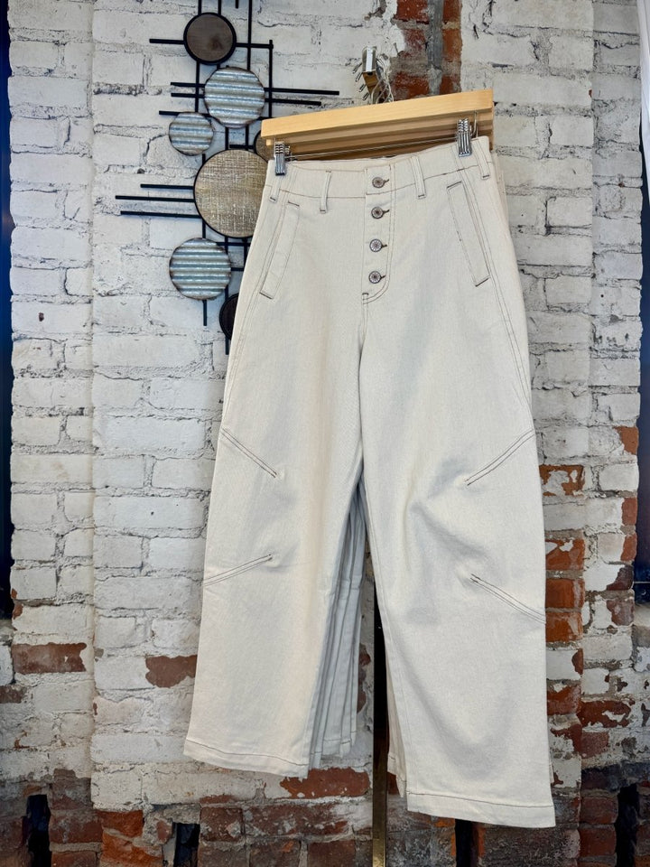 Entro ecru straight leg pants hanging in a boutique, showcasing the full length and clean straight-leg silhouette.