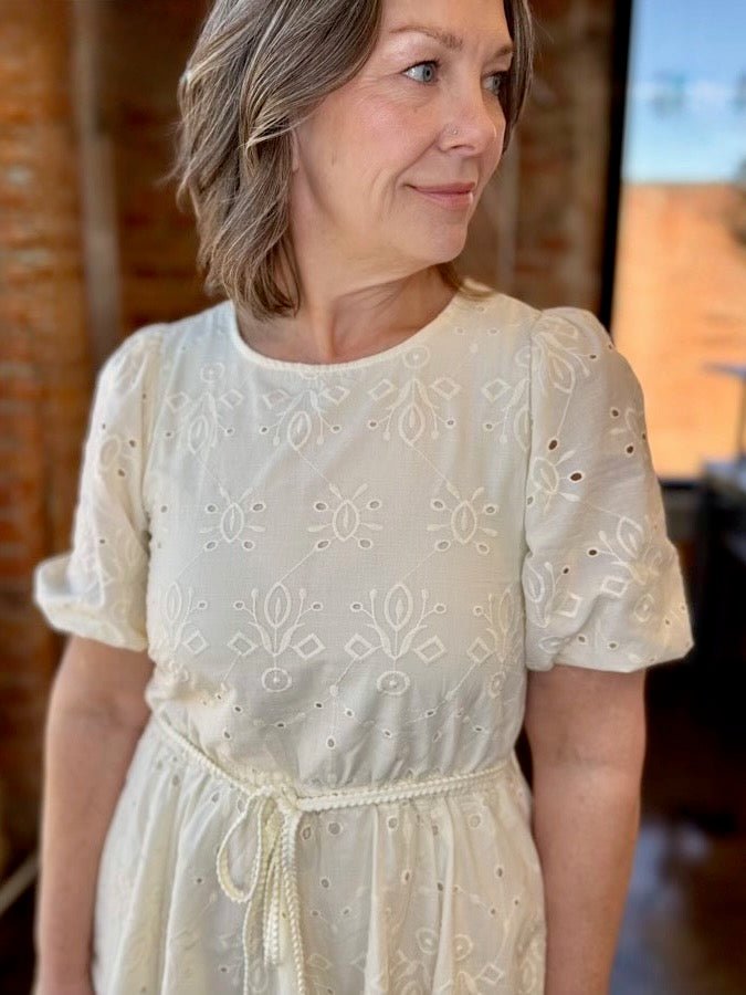 Close-up of Black Tape Eyelet Belted Mini Dress bodice with floral eyelet embroidery, puff sleeves, and rope tie waist detail
