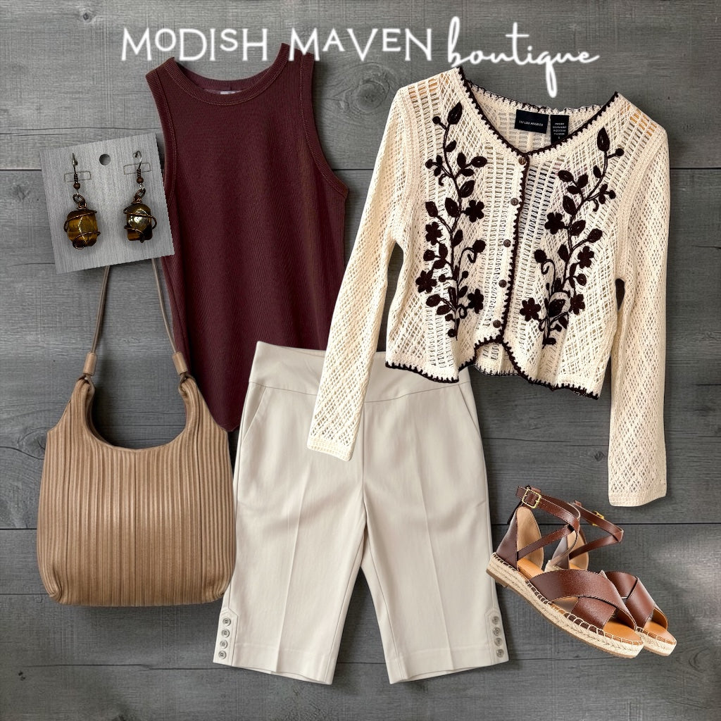 Fashionable outfit with maroon tank top, beige lace cardigan, beige pants, brown sandals, and beige handbag on a wooden surface with 'Modish Maven' branding.