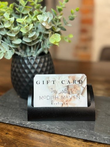 Modish Maven gift card in a holder with a plant in the background