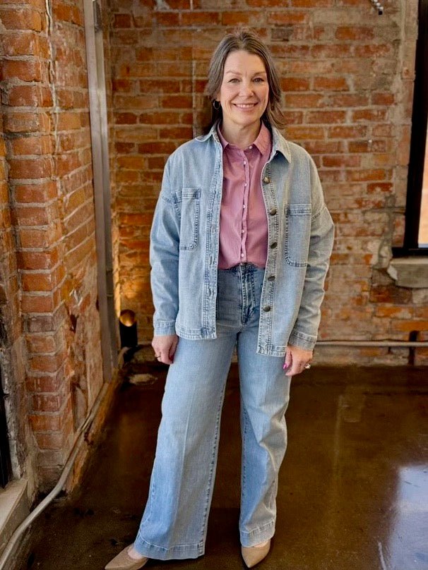Dear John Denim Gina Relaxed Fit Denim Jacket in Zurie wash, relaxed fit with functional pockets, styled over pink button-down and wide-leg jeans, front view on model
