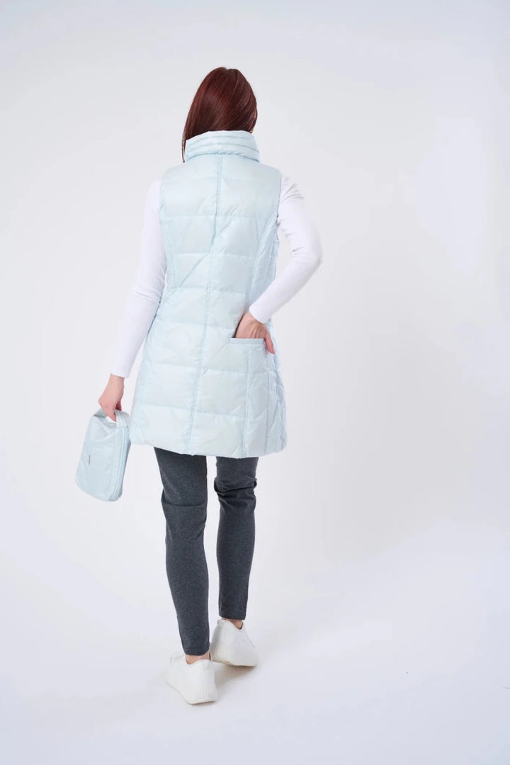Person wearing a light blue puffer vest on a white background