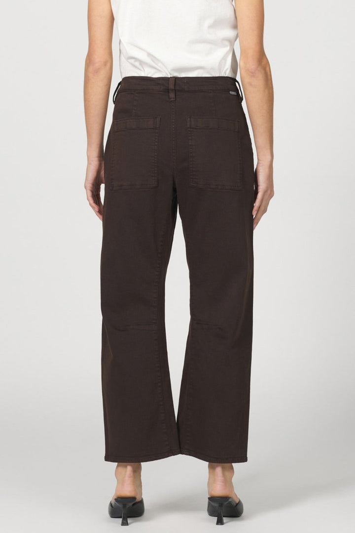 Person wearing dark brown cargo pants on a white background