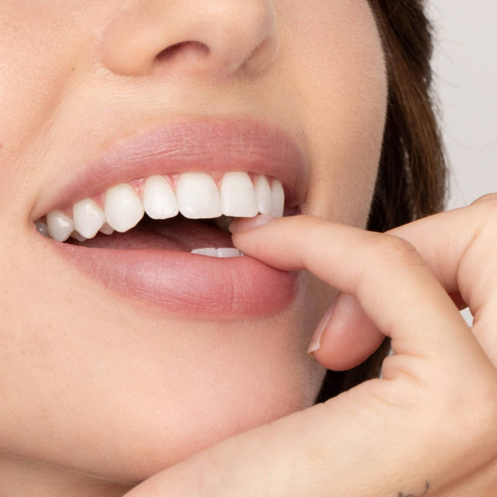 A detailed close-up of a person wearing Beverly Lip Tint, showing the sheer, buildable mauvy pink color with a smooth finish.