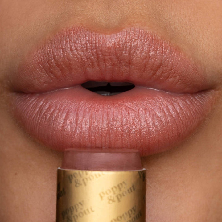 A buttery application of Debbie Lip Tint on lips, displaying the warm dark peach pigment and smooth, natural texture.