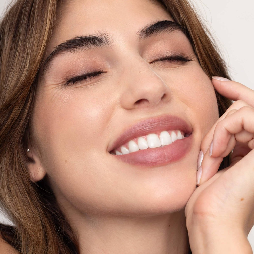 A close-up of Donna Lip Tint on lips, showing a sheer, buildable plum wash of color with a moisturizing, healthy finish.