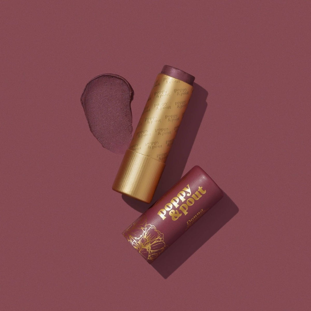 Poppy and Pout Donna Lip Tint in sustainable cardboard packaging, featuring a sheer plum natural balm.