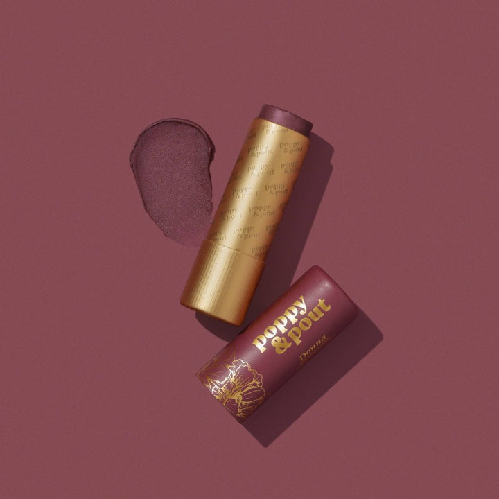 Poppy and Pout Donna Lip Tint in sustainable cardboard packaging, featuring a sheer plum natural balm.