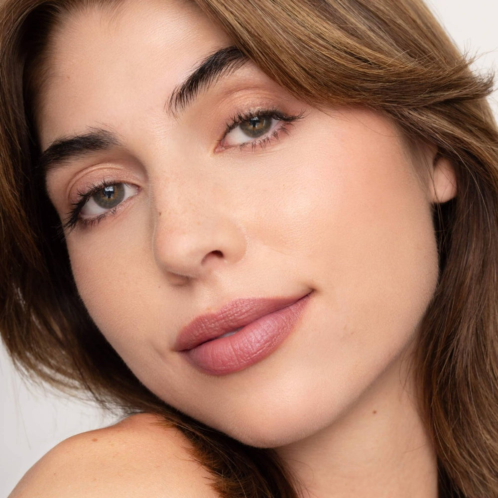 A deep wine lip tint applied to lips for a sheer berry-stained look with a moisturizing, healthy finish.
