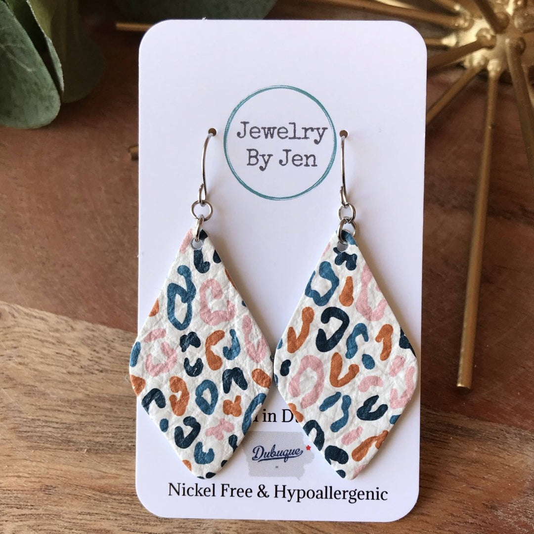 Leopard print earrings on a 'Jewelry By Jen' card with a wooden background