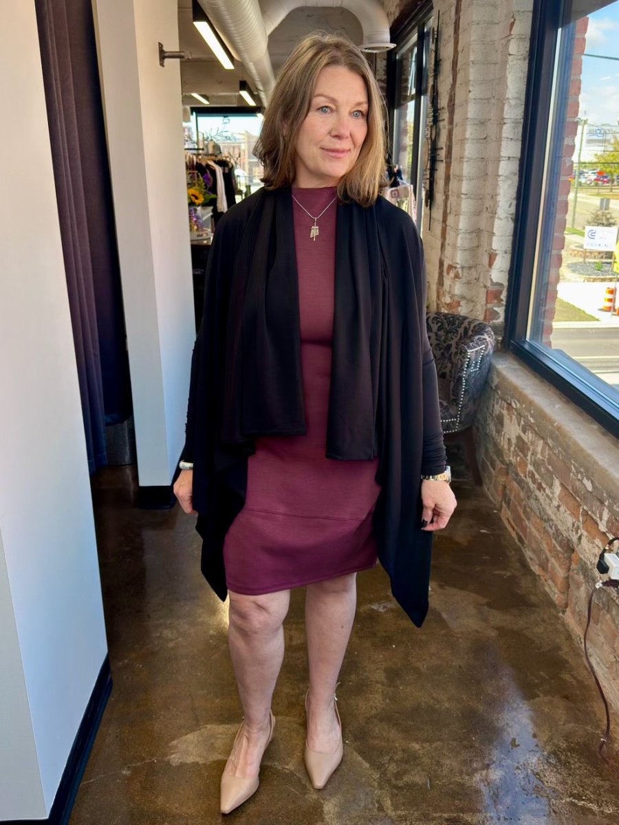The plum Juno Dress styled with a long black open-front cardigan, demonstrating a perfect transitional outfit for effortless boutique fashion.