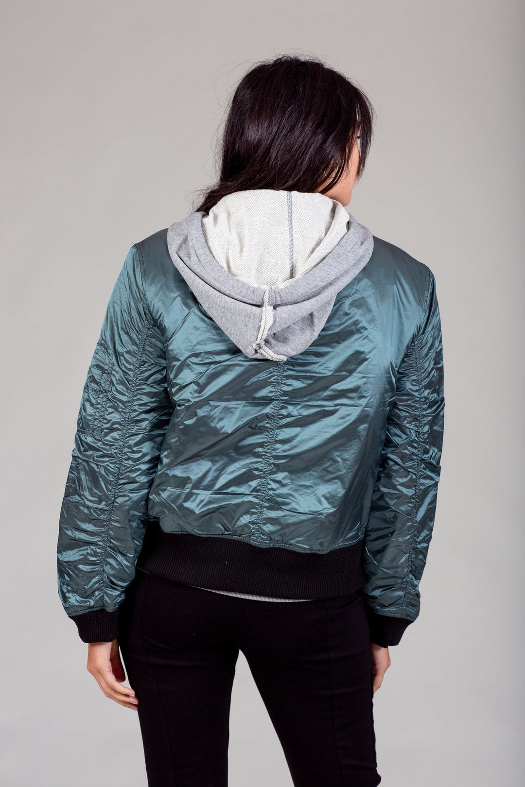 My Anorak Iridescent Hooded Down Bomber Jacket in Kryptonite — rear view on model showing the hoodie and knit waistband