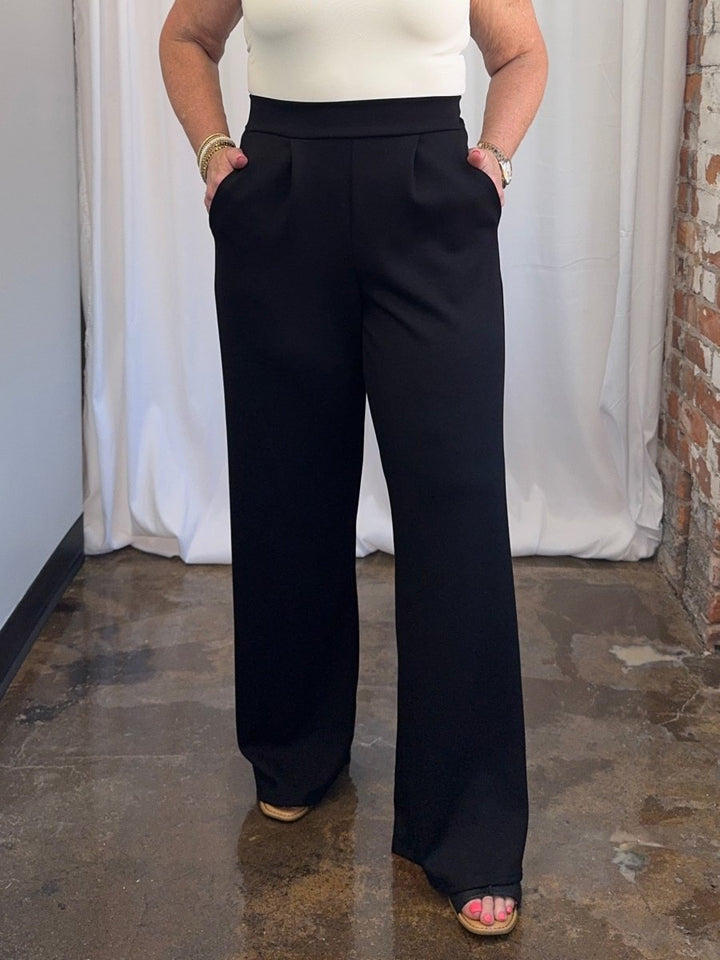 Carole Christian Pleated Wide-Leg Scuba Modal Pant in Black, front view on model, tailored pleats and side pockets