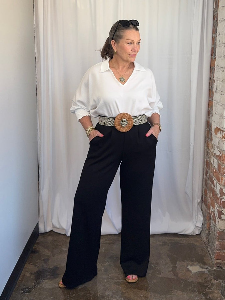 Carole Christian Pleated Wide-Leg Scuba Modal Pant in Black styled with white button-down shirt and statement belt, full outfit on model