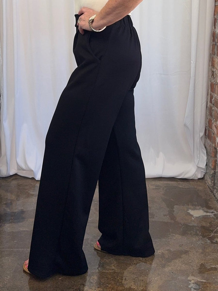 Carole Christian Pleated Wide-Leg Scuba Modal Pant in Black, side view on model showing wide-leg silhouette and elastic waistband