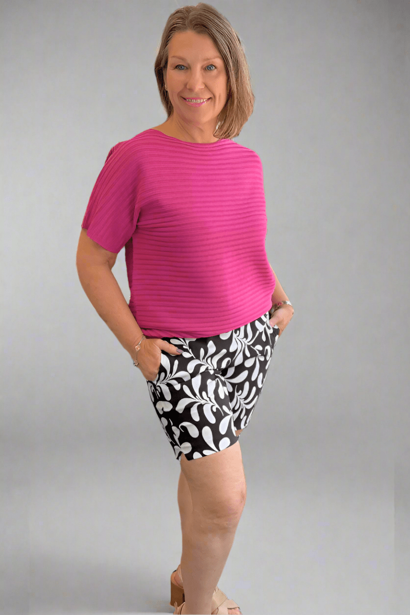 Woman wearing printed high-rise stretch shorts in soft millennium fabric with a 7-inch inseam.