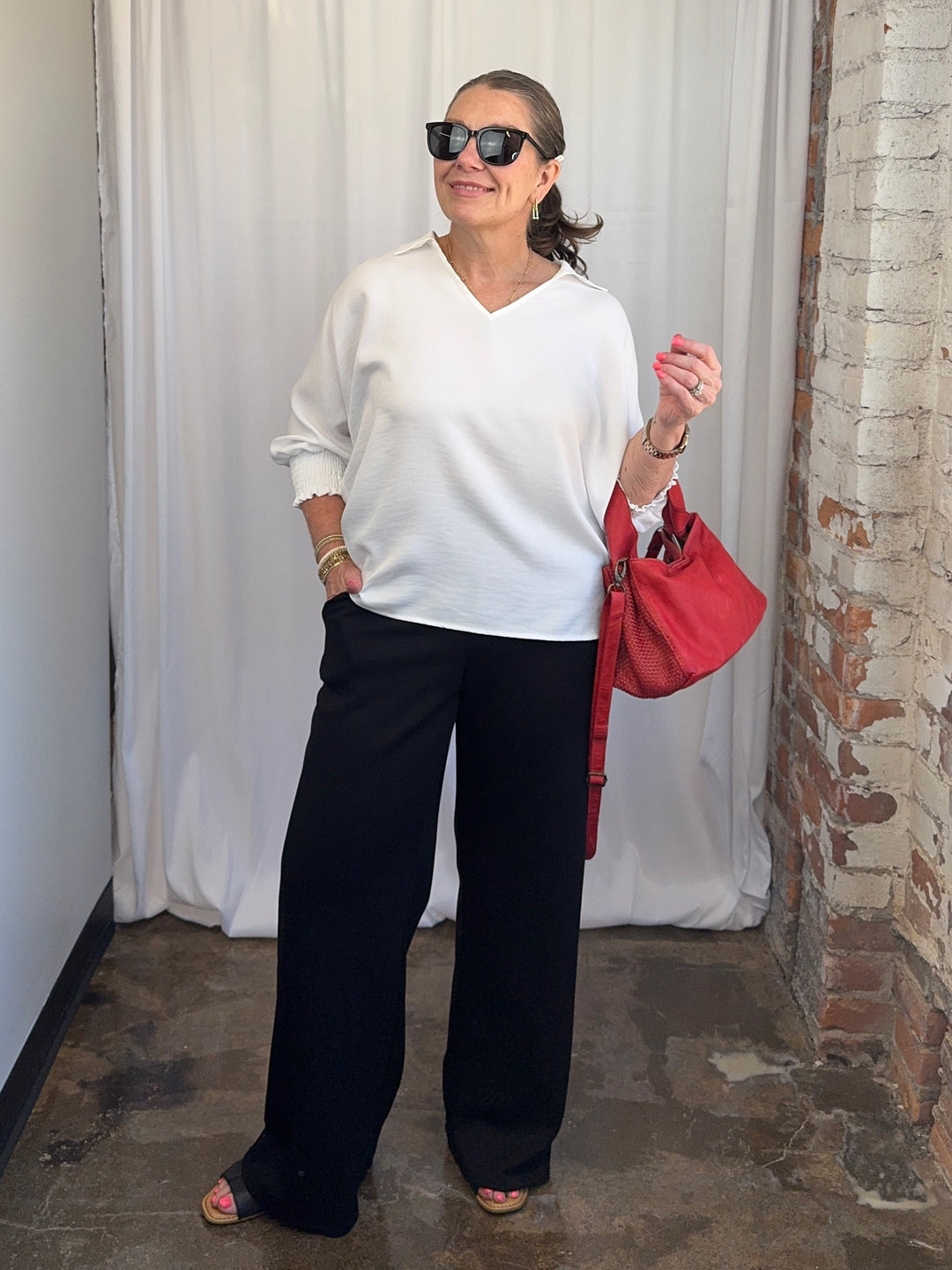 Carole Christian Relaxed Collar V-Neck Smocked Sleeve Blouse in White — full outfit view on model, untucked with red bag