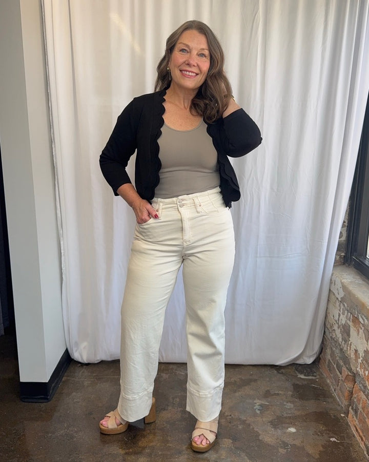 Zac &amp; Rachel Scallop Knit Shrug Cardigan in Black styled with taupe tank and cream wide-leg jeans, full outfit front view on model
