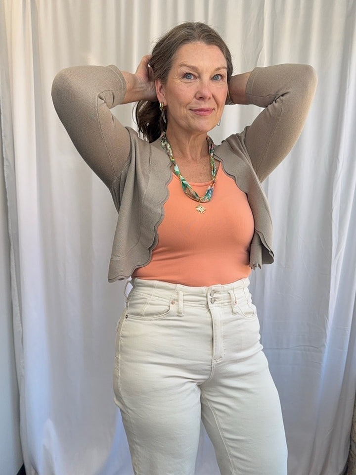 Scallop Knit Shrug Cardigan in Cobblestone styled with peach tank and cream wide-leg jeans, full outfit front view on model
