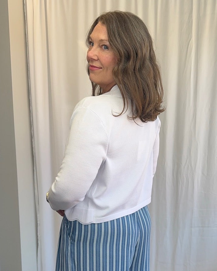 Scallop Knit Shrug Cardigan in White showing scallop hem detail and 3/4 sleeve length, back view on model
