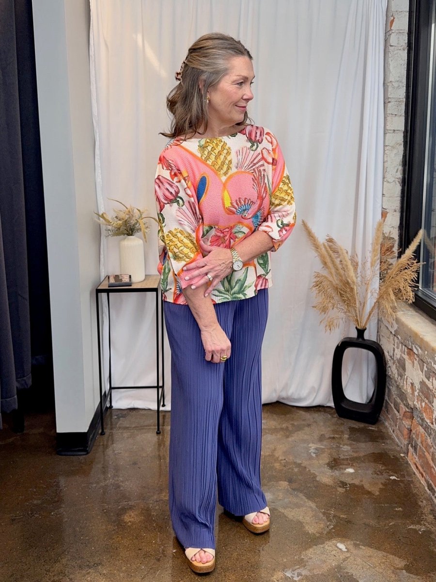 Styled look featuring the Made in Italy printed batwing top paired with bright blue pleated wide-leg trousers.