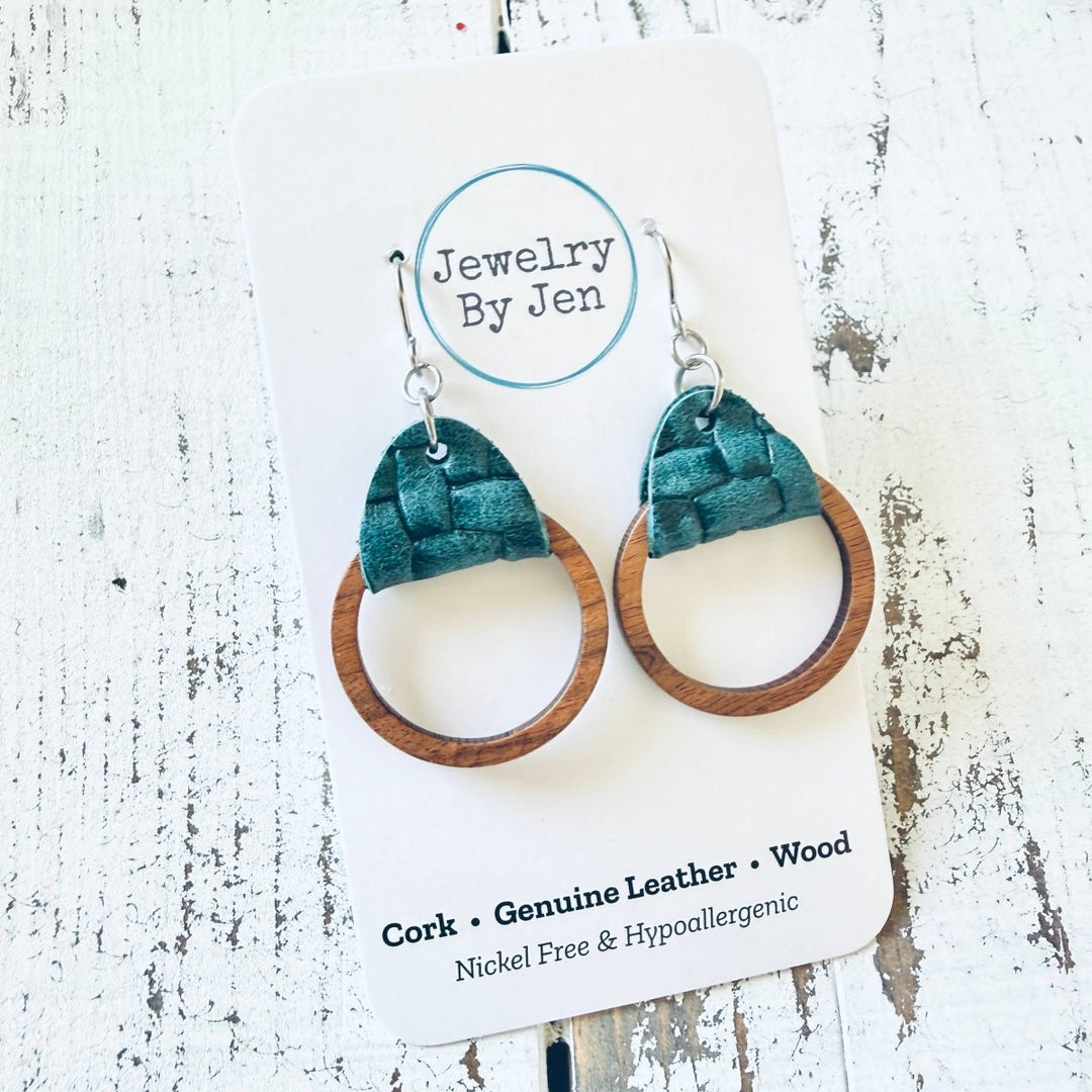 Pair of earrings with green fabric and wooden hoop on a &