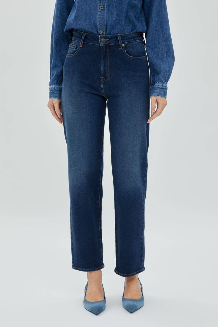 Woman wearing dark wash denim shown in a close view.